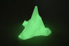 Glow-in-the-dark Titanic iceberg model glowing bright green in a dark room