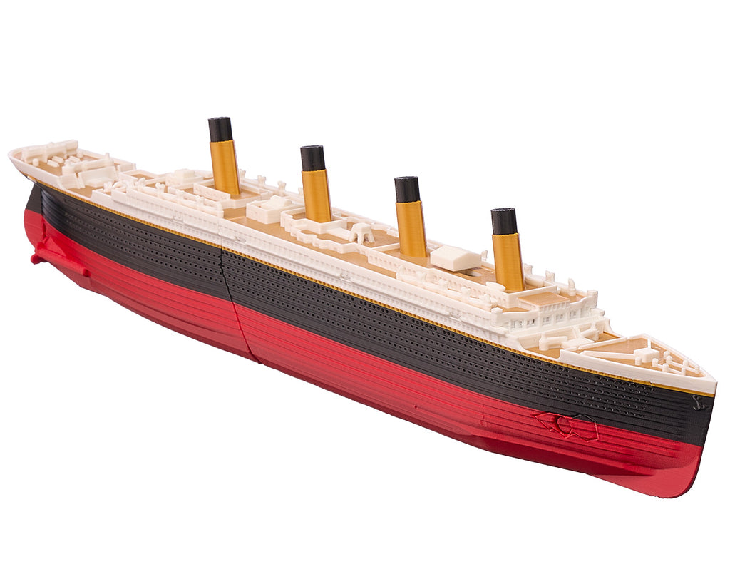 Sinkable Titanic model seen from the bow, showing the red lower hull and black upper hull, hull break, wood colored decks, and sink-mode thumb switch.